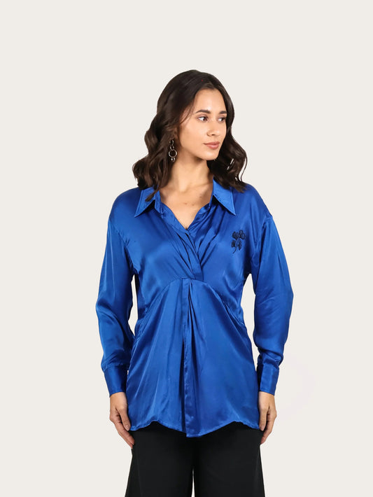Woman wearing a blue shirt and black pants on a white background
